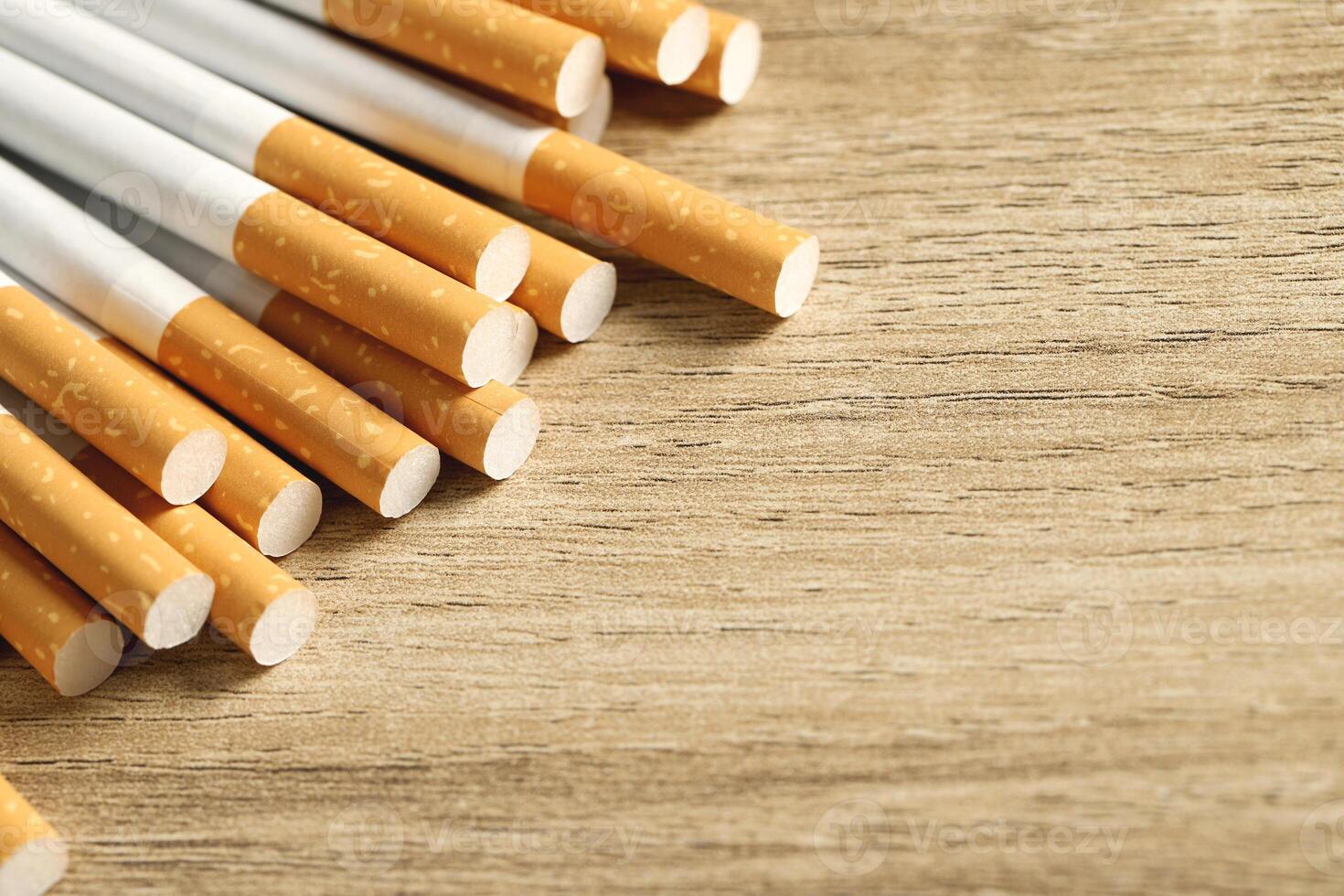 image of several commercially made pile cigarette on wood background. or Non smoking campaign concept, tobacco pattern top view photo
