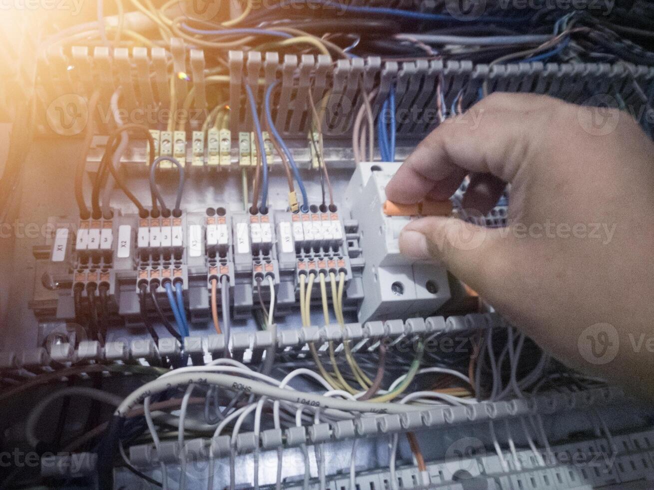 The electrician turn off the circuit breaker on the panel control machine. Electrician check and service concept. photo