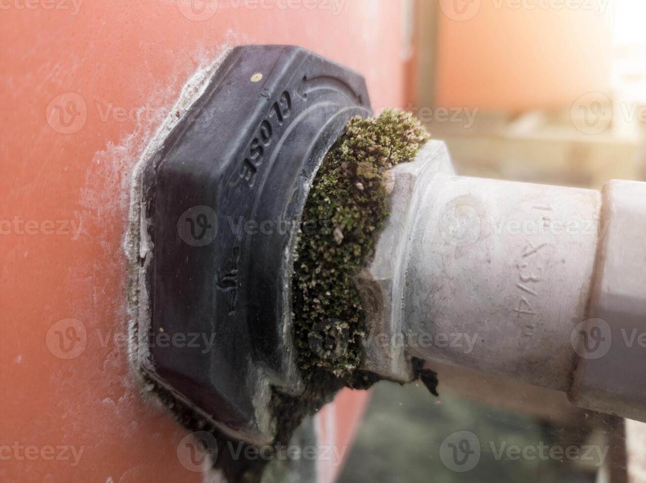 el toma de corriente tubo línea en el agua reservorio es cubierto de musgo debido a un agua filtración. foto