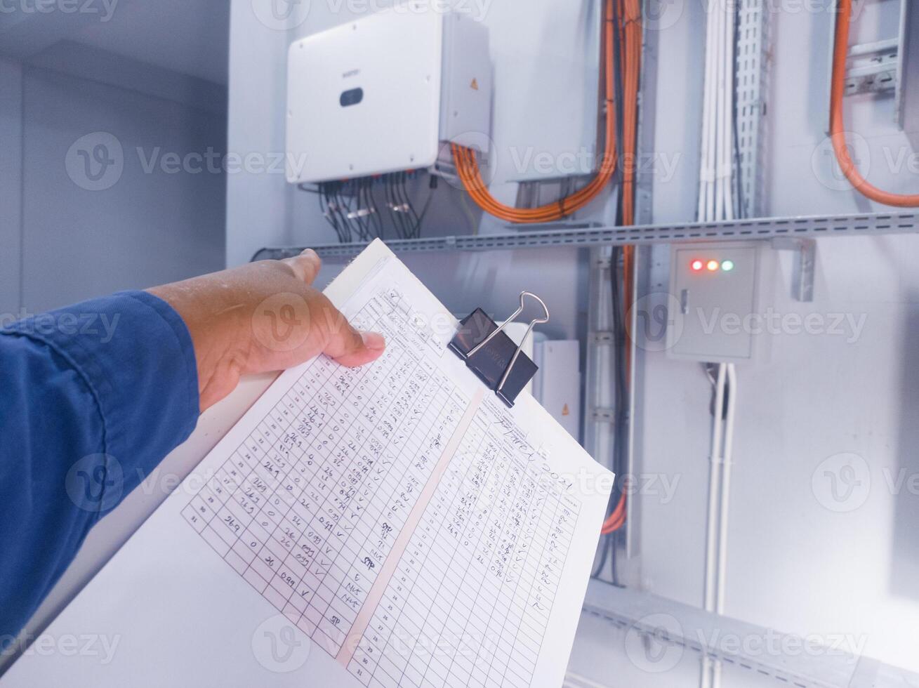 An inspector is pointing to the solar panel inverter module, having the concept of checking and monitoring the solar panel inverter. comissioning concept. photo