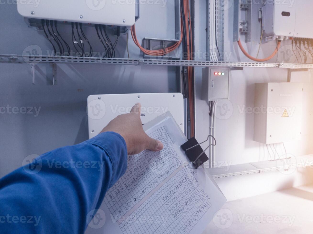 An inspector is pointing to the solar panel inverter module, having the concept of checking and monitoring the solar panel inverter. comissioning concept. photo