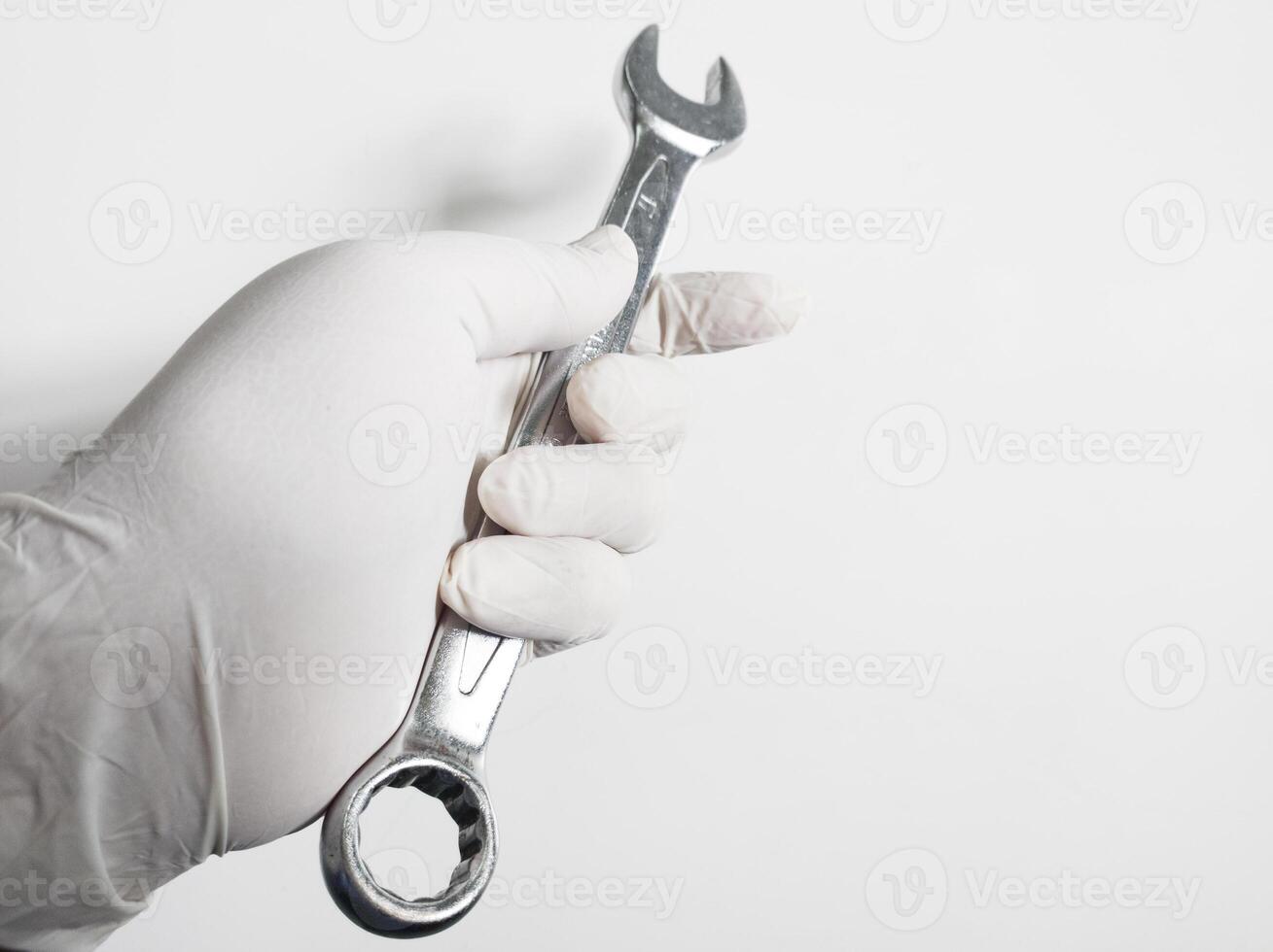 del hombre mano con guantes sostiene un llaves inglesas aislado en blanco antecedentes. mecánico herramientas concepto. foto