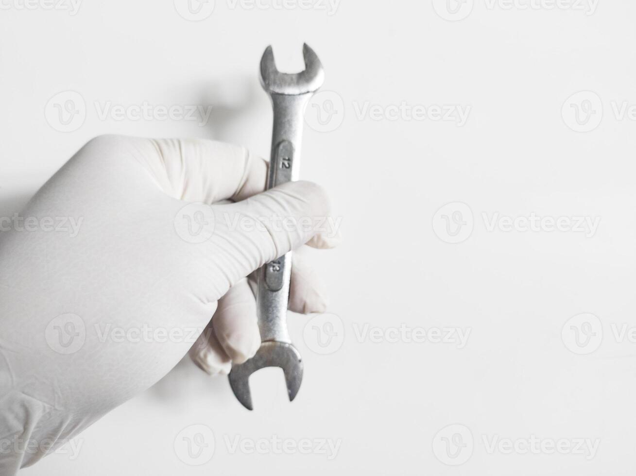 Man's hand with gloves holds a wrench tools isolated on white background. photo