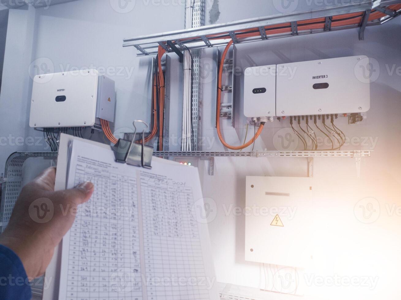 An inspector is pointing to the solar panel inverter module, having the concept of checking and monitoring the solar panel inverter. comissioning concept. photo