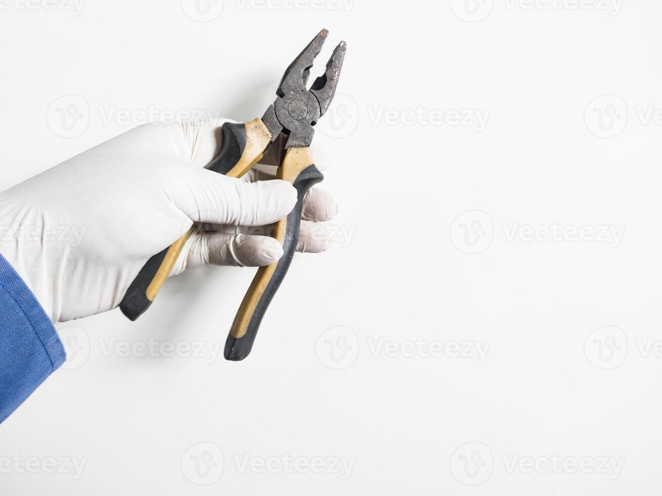 Man's hand holds a pliers yellow and black color isolated on white background. photo