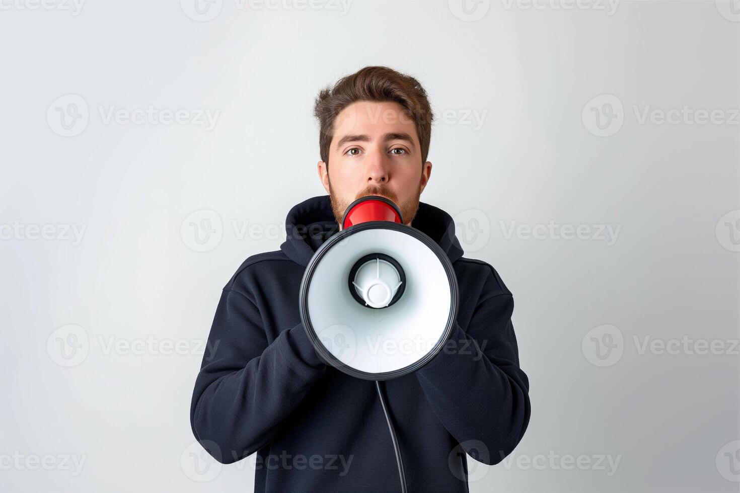 Black hoodie man holding megaphone announces discounts sale, man shouting through a megaphone. isolated on gray background photo