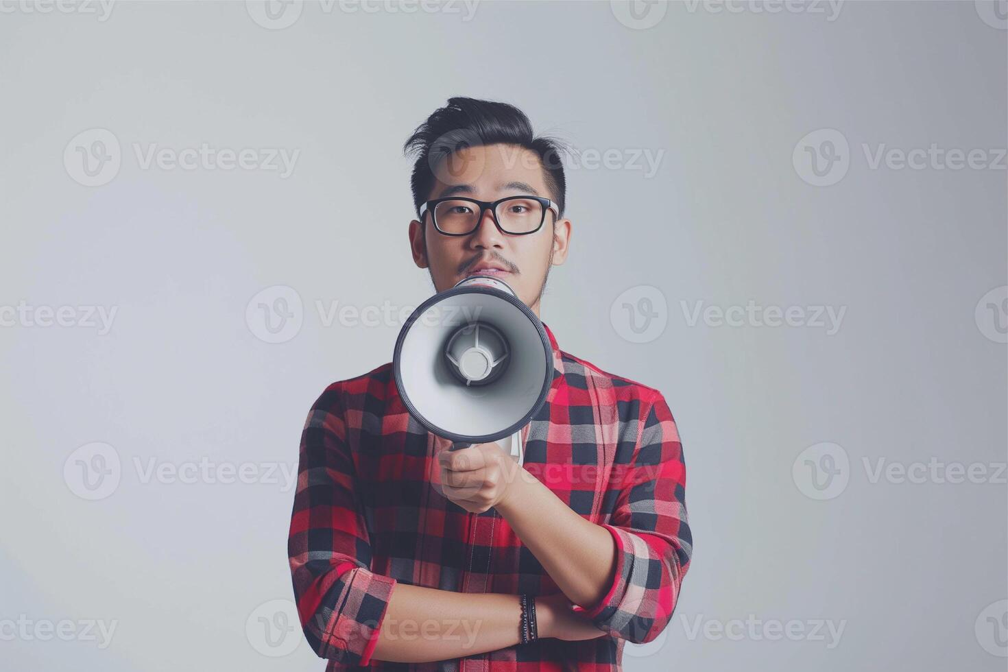 Asian guy wearing a plaid shirt man holding megaphone announces discounts sale photo