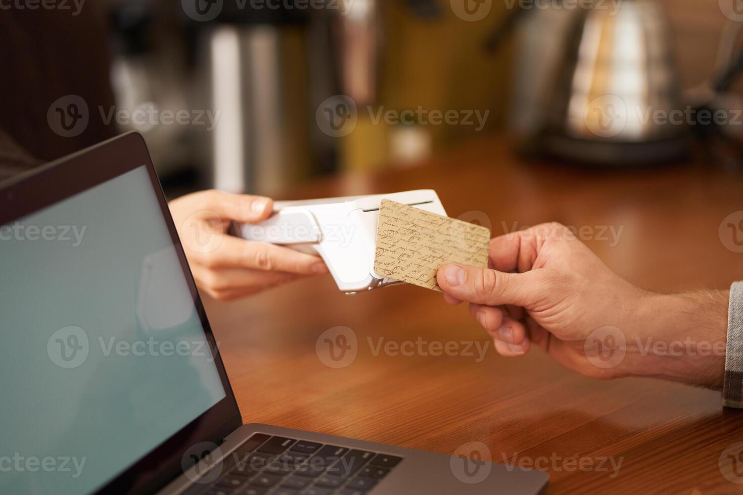 Close up cropped shot, male hand holding credit card, paying contactless by pressing it to the POS terminal, making purchase, completing order in cafe photo