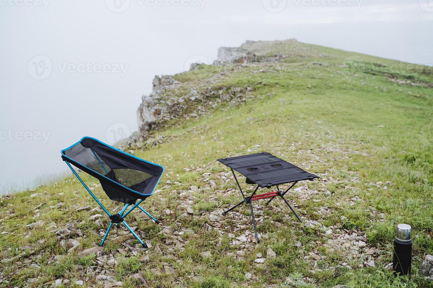 Chair and camping table furniture camping stands on a mountain against the backdrop of nature gear tourist compact lightweight folding utensils photo