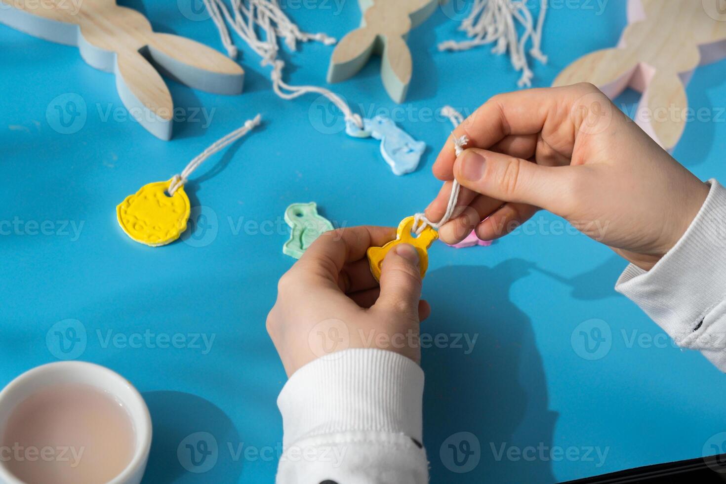 creador es utilizando blanco aire seco arcilla para haciendo decoración a Pascua de Resurrección día festivo. creando pasatiempo recreación actividad ese involucra dedos. bricolaje elaboración moderno Arte foto