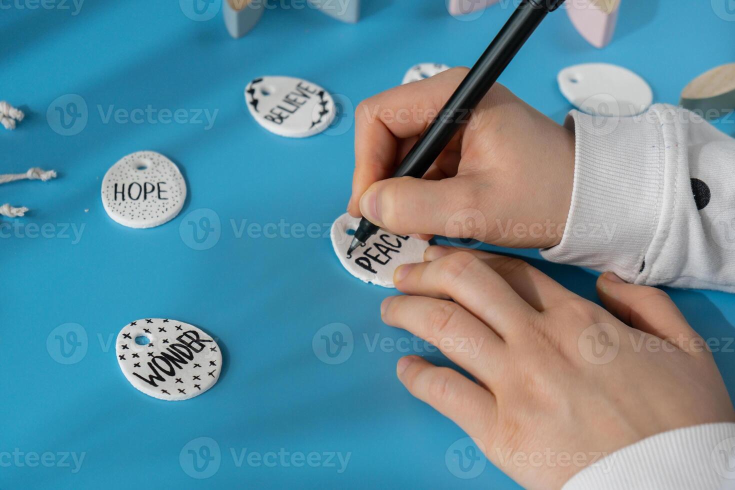 Maestro clase escritura palabra paz en Pascua de Resurrección arcilla huevo creador es utilizando blanco aire seco arcilla para haciendo decoración a Pascua de Resurrección día festivo. creando pasatiempo recreación actividad ese involucra dedos. bricolaje elaboración moderno Arte foto