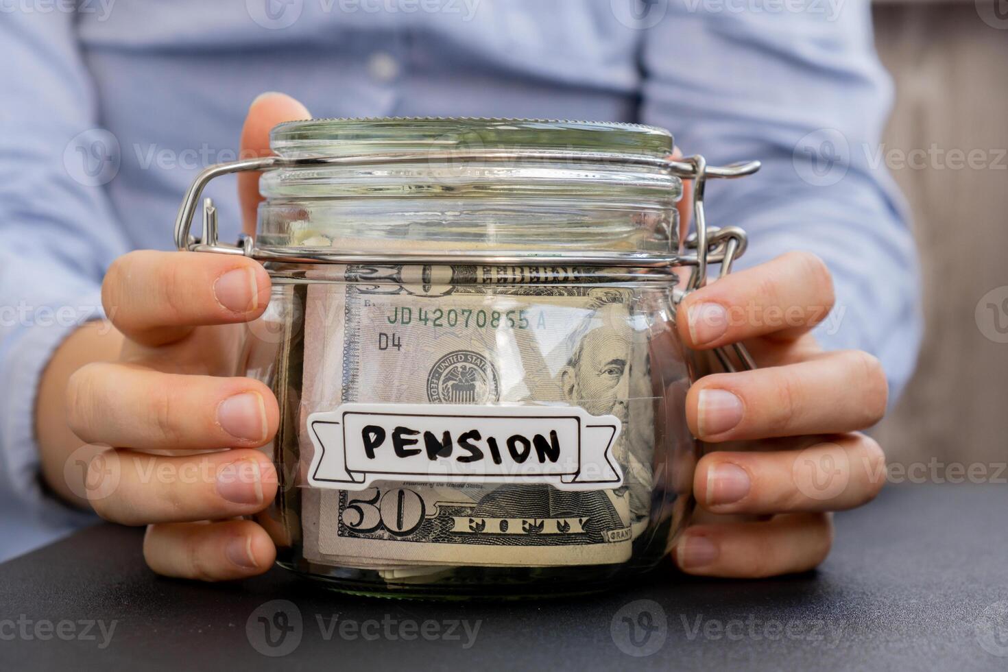 Unrecognizable woman holding Glass jar full of American currency dollars cash banknote with text PENSION. Preparation saving money. Moderate consumption and economy. Collecting money photo