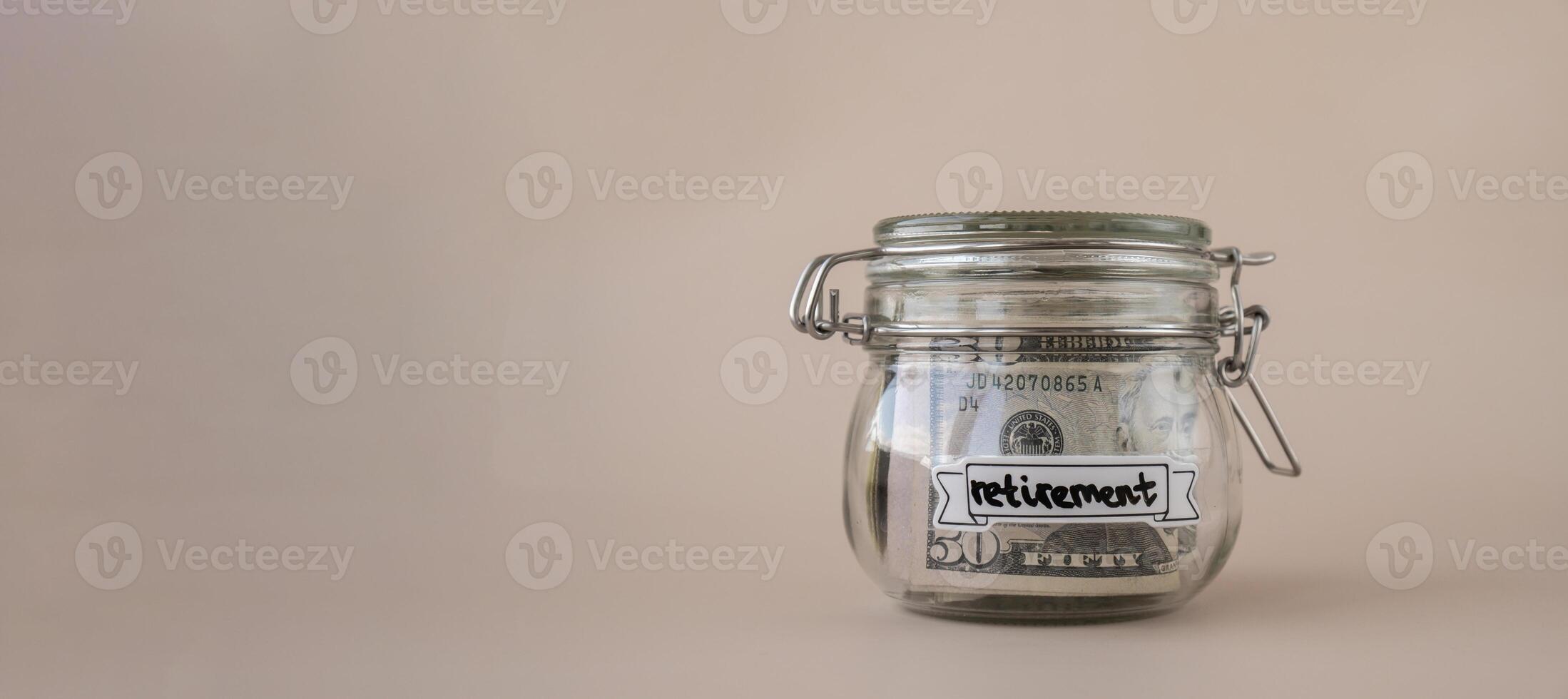 Glass jar full of American currency dollars cash banknote with text RETIREMENT. Preparation saving money. Moderate consumption and economy. Collecting money photo