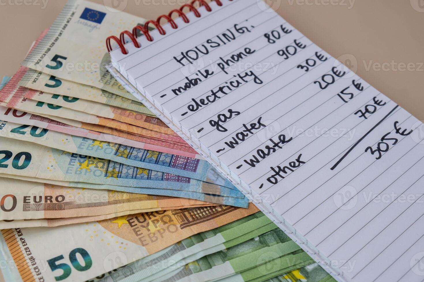 euro efectivo dinero con cuaderno escrito alojamiento gastos. contando cuentas para electricidad, gas, agua. concepto de eficiente consumo y economía. gasto hábitos foto