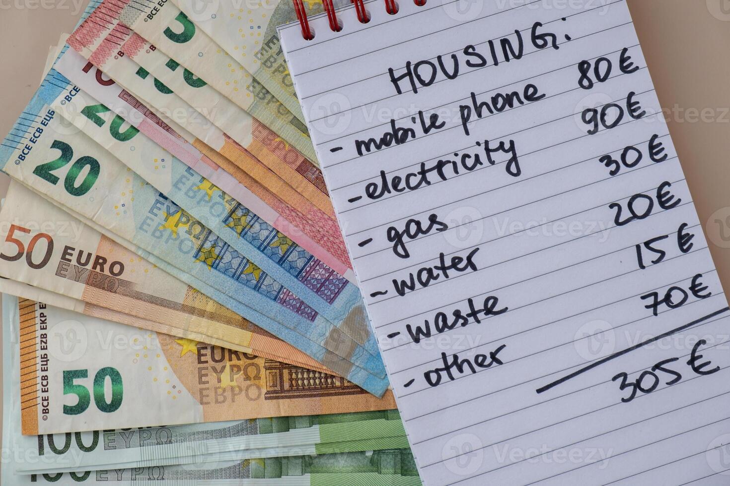 Euro cash money with notebook handwritten housing expenses. Counting bills for electricity, gas, water. Concept of Efficient Consumption and Economy. Spending habits photo