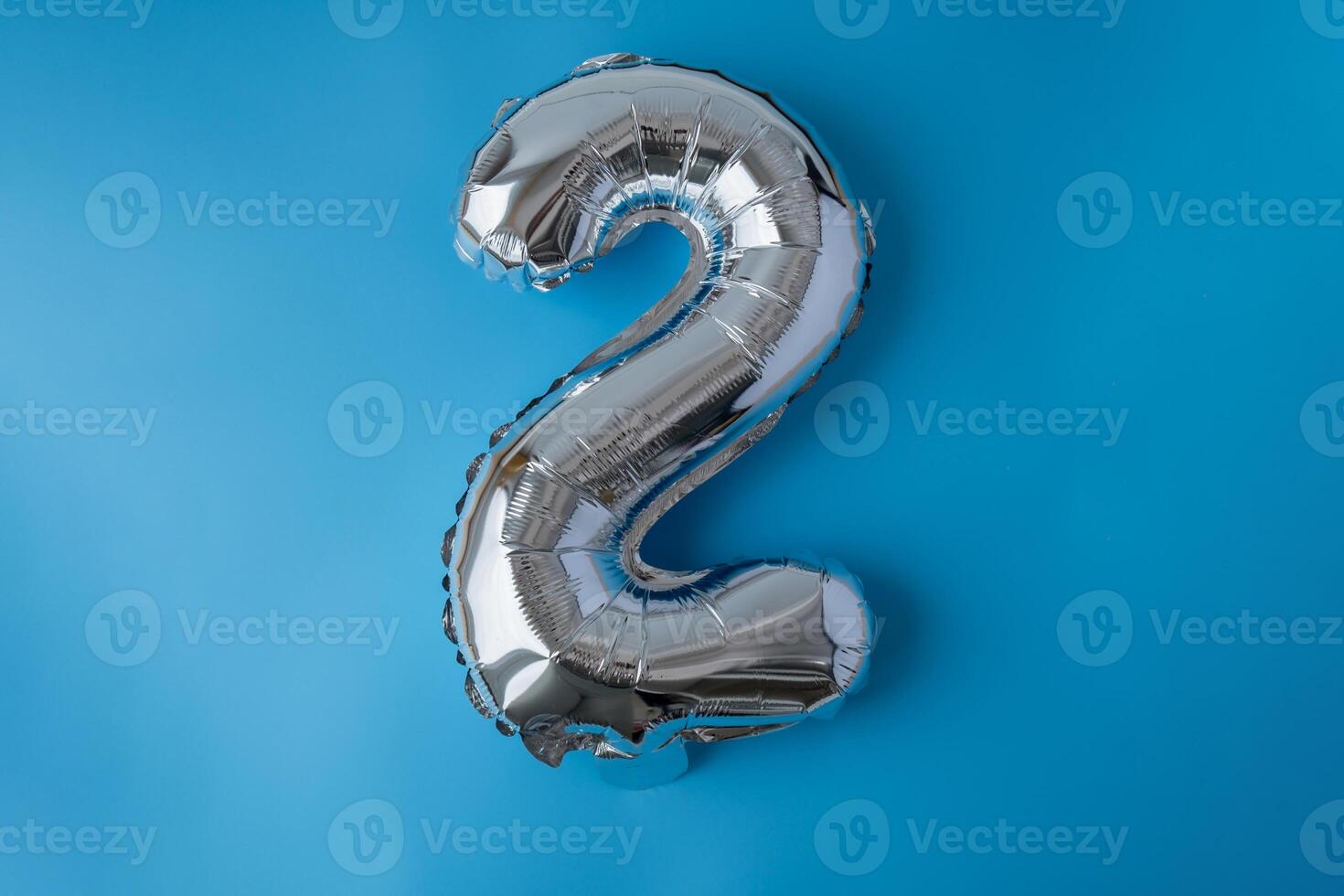 2 two metallic balloon isolated on blue background. Greeting card silver foil balloon number Happy birthday holiday concept. Copy space for text. Celebration party congratulation decoration photo