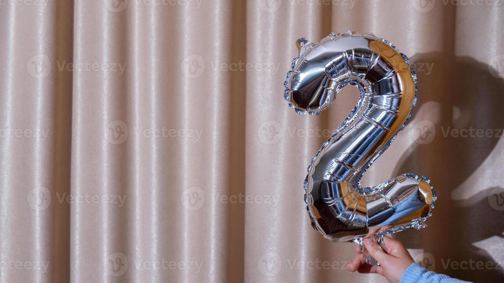 2 two metallic balloon isolated on Altas textile background. Greeting card silver foil balloon number Happy birthday holiday concept. Copy space for text. Celebration party congratulation decoration photo