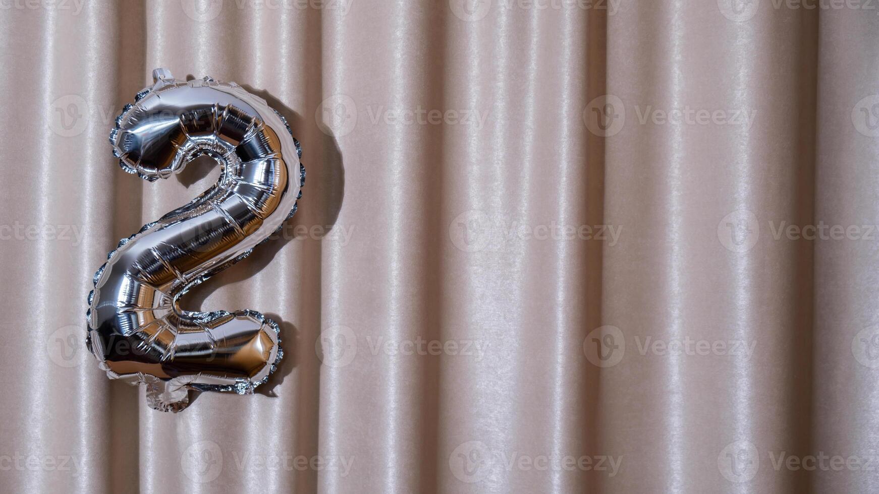 2 two metallic balloon isolated on Altas textile background. Greeting card silver foil balloon number Happy birthday holiday concept. Copy space for text. Celebration party congratulation decoration photo