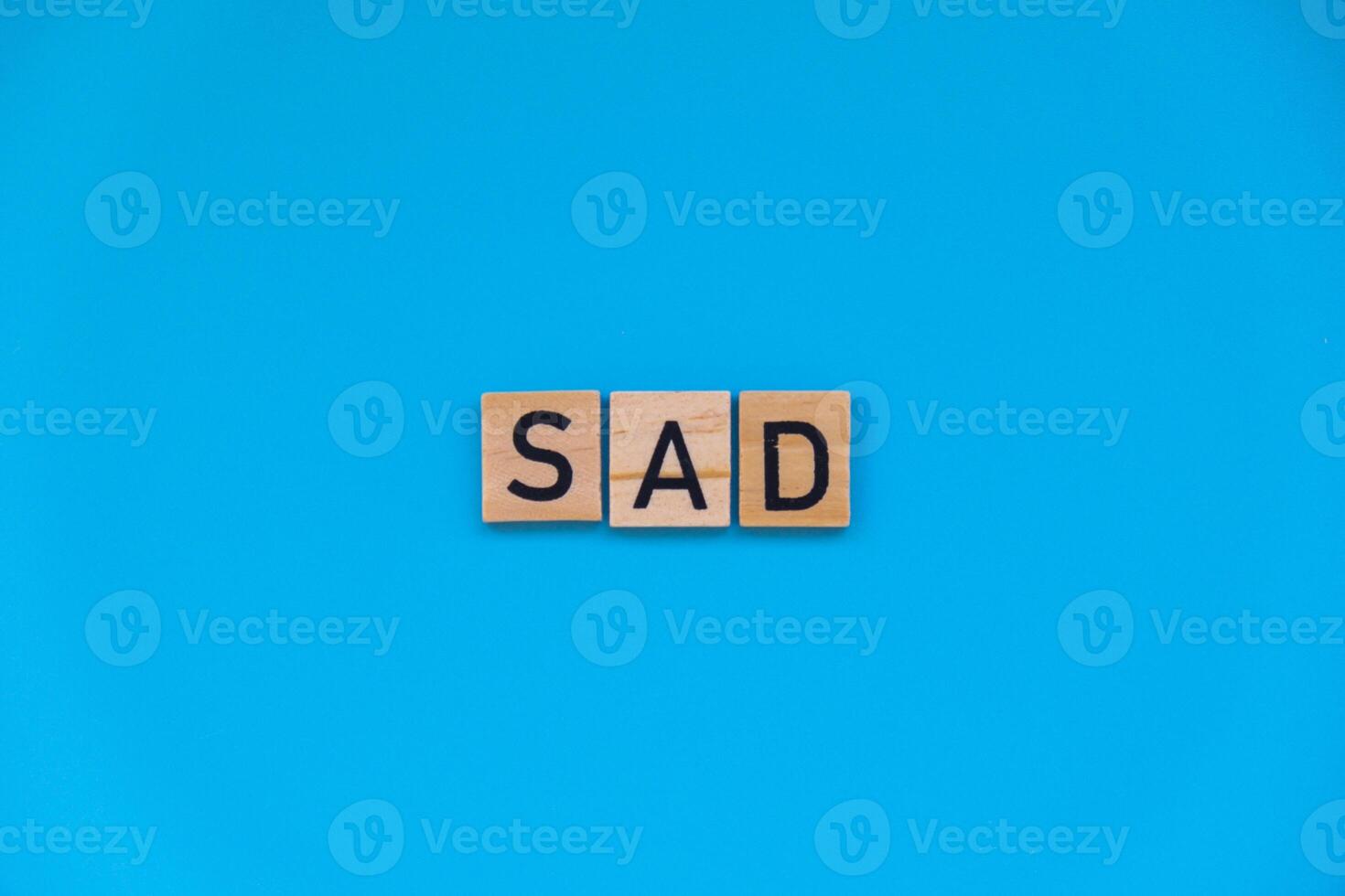 Seasonal affective disorder - text of wooden blocks on blue bright background. Concept of depression mood stress and anxiety. SAD wellbeing photo