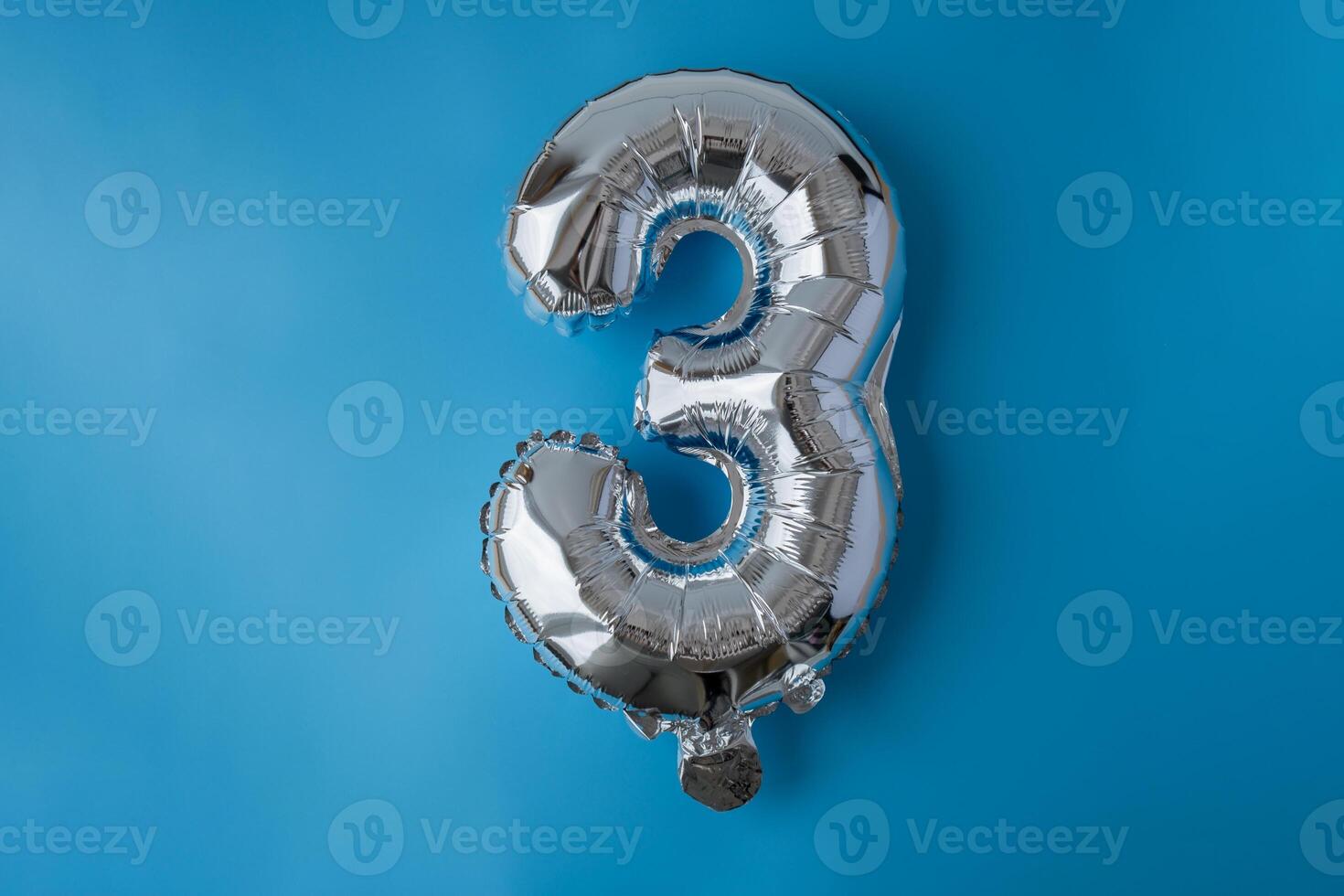 3 three metallic balloon isolated on blue background. Greeting card silver foil balloon number Happy birthday holiday concept. Copy space for text. Celebration party congratulation decoration photo