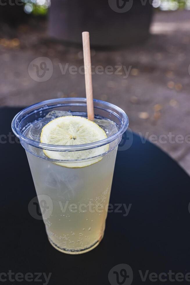 A chilled glass of lemonade topped with a lemon slice photo