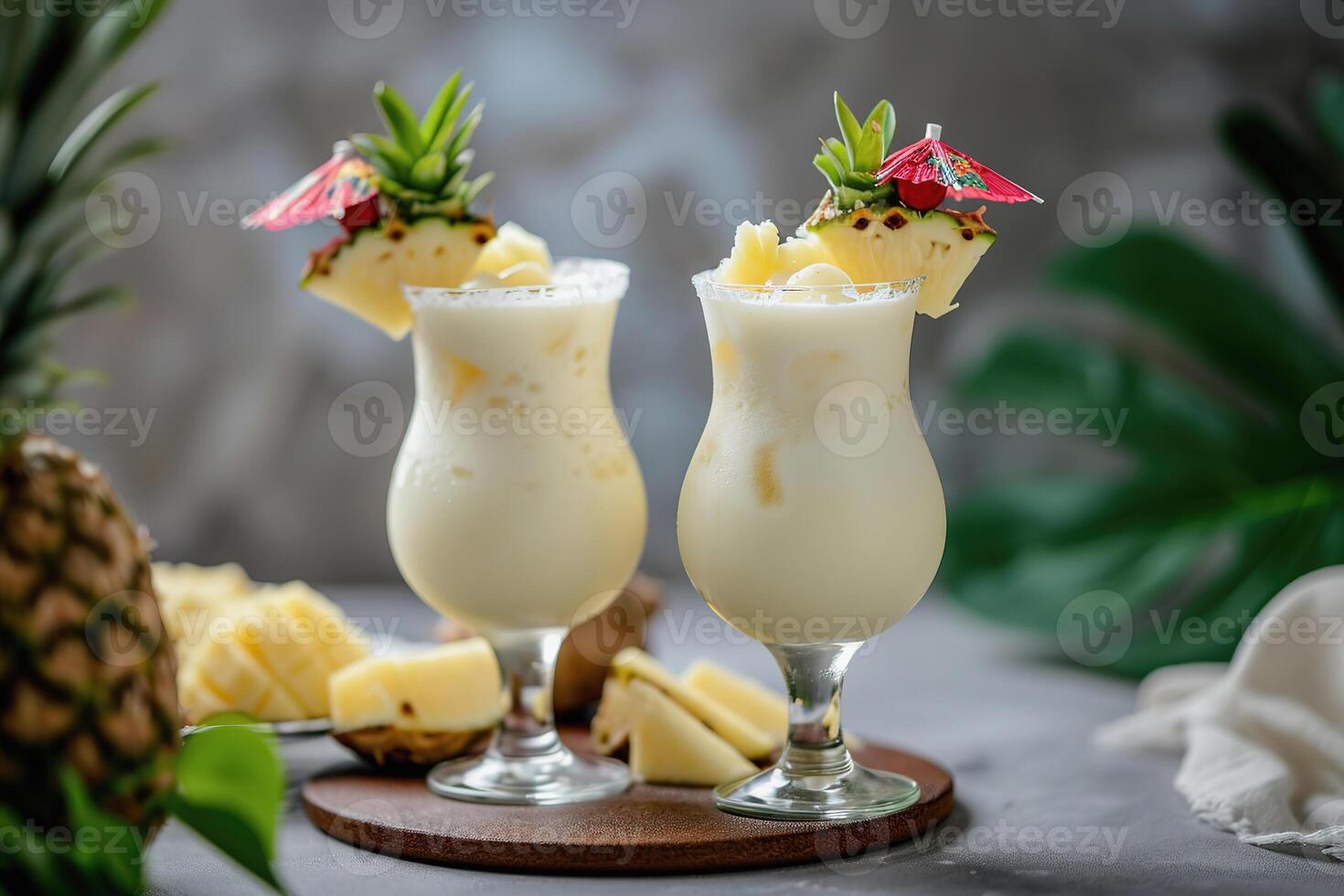 Two creamy pina colada drinks with pineapple garnish, tropical background photo