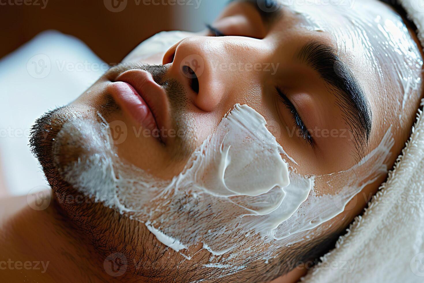 Hispano hombre relajante con blanco facial máscara tratamiento en spa configuración, parte superior ver foto