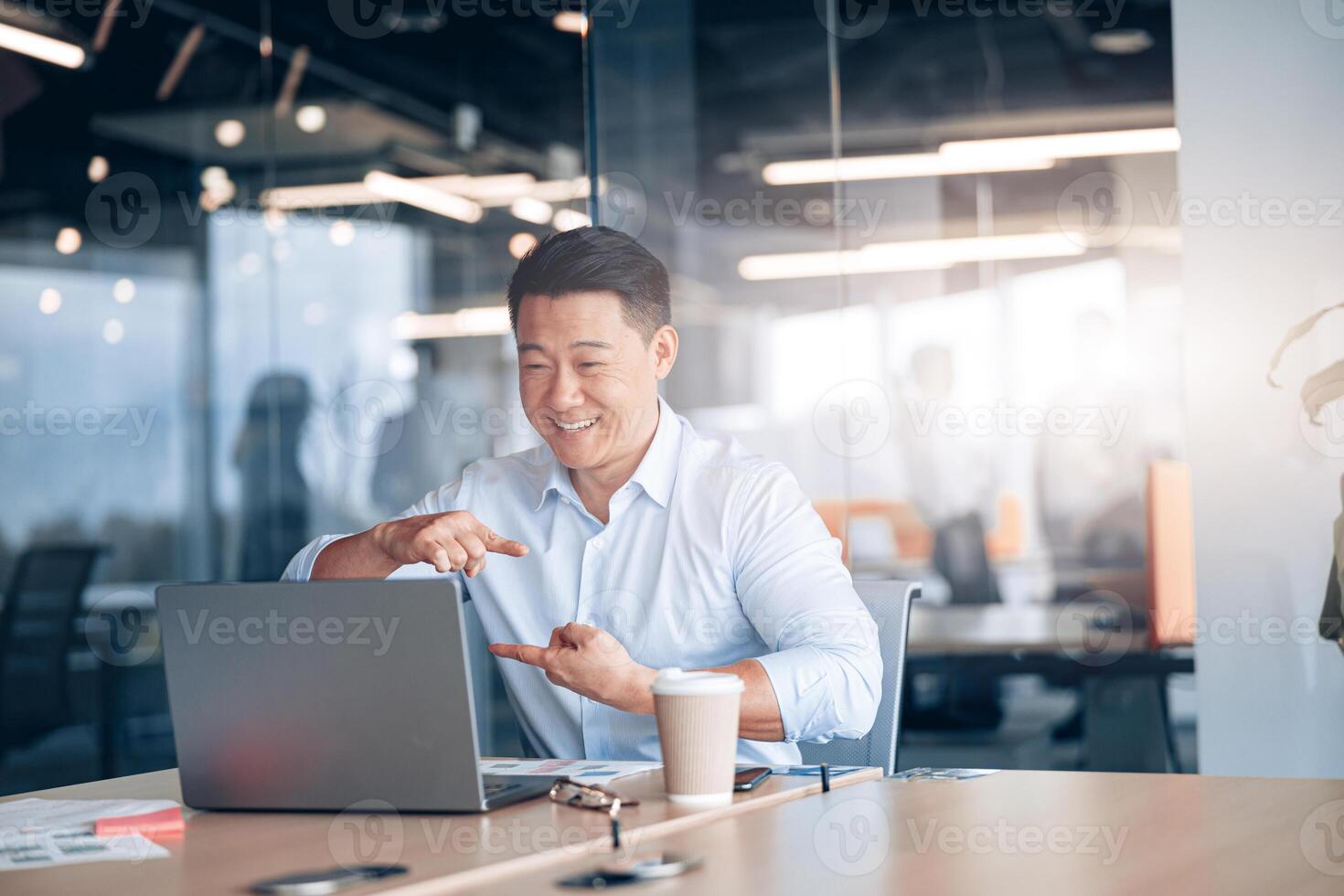Asian businessman communicating in call with deaf client at her workplace photo