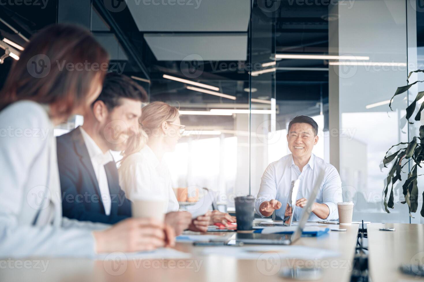 Beautiful business people are using gadgets, talking and smiling during the conference in office photo