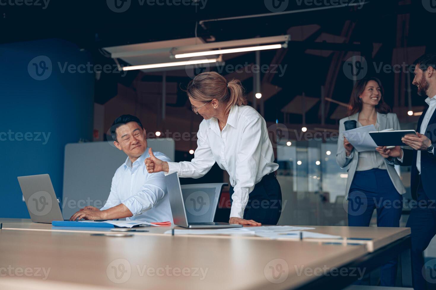 Happy mature female employee discussing online project, showing presentation to skilled team leader photo