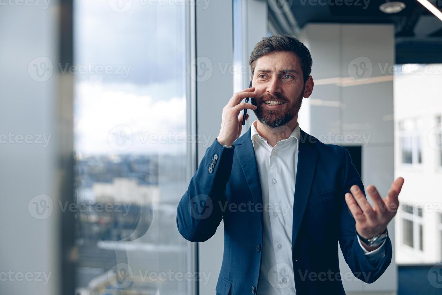 Portrait of inspired man using mobile phone and making a call his business partner at office photo