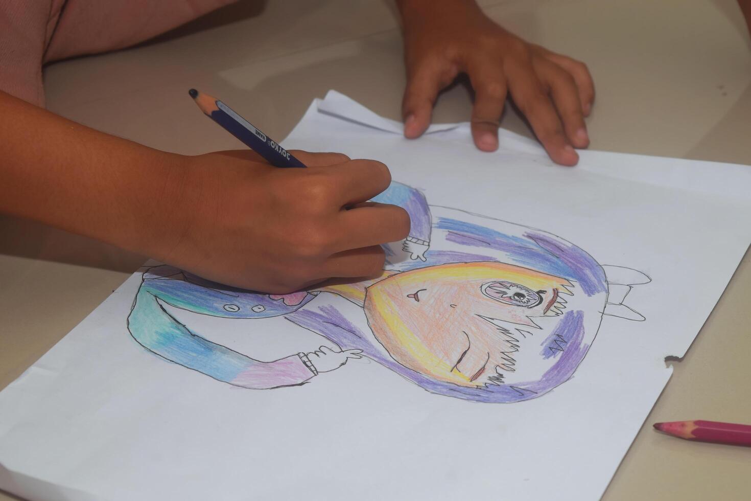 un niño es dibujo y colorante su trabajo foto