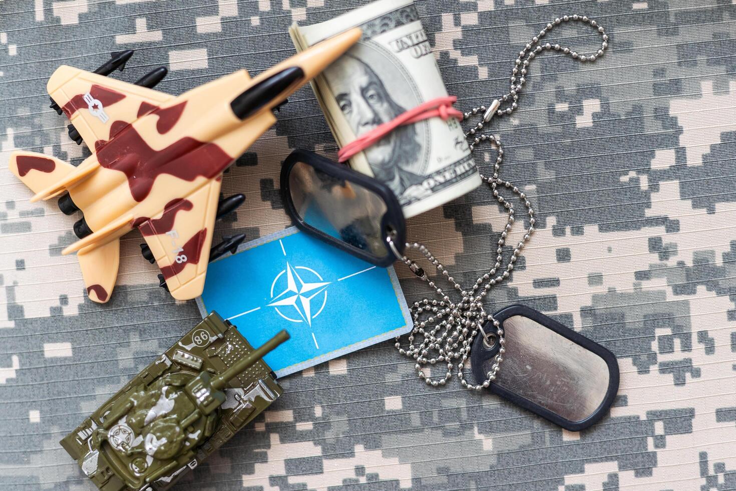 Military ID tags with chain on camouflage uniform, toned in colors of Ukrainian flag war photo