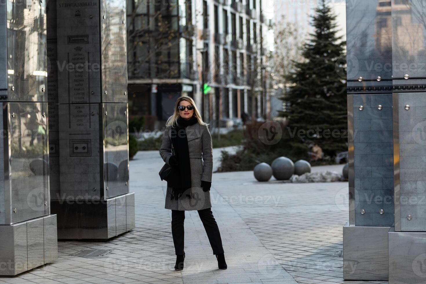 A young girl blonde walks through the city photo