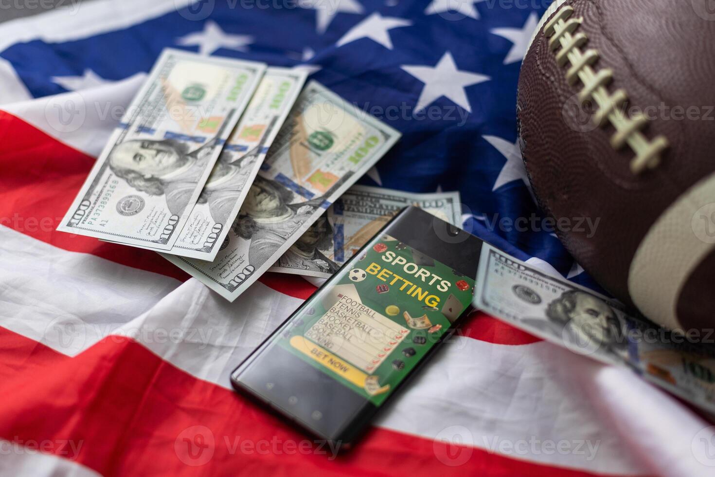 Online sports betting. Dollars are falling on the background of a hand with a smartphone and a soccer ball. Creative background, gambling photo