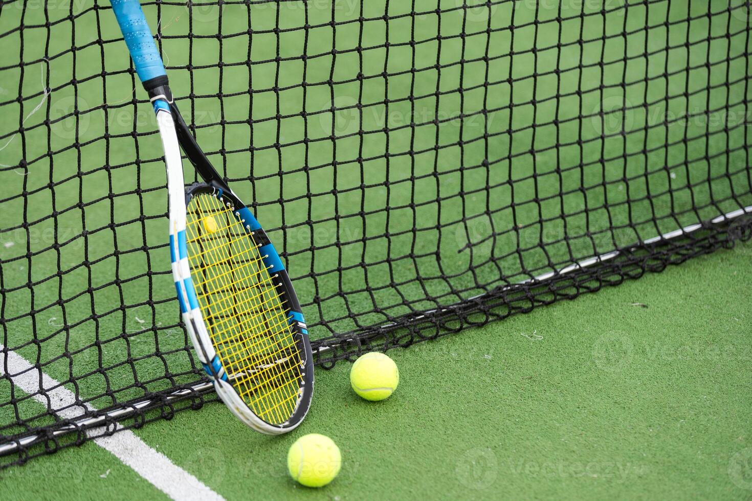 tenis raqueta y tenis pelota además el red en al aire libre tenis corte. foto