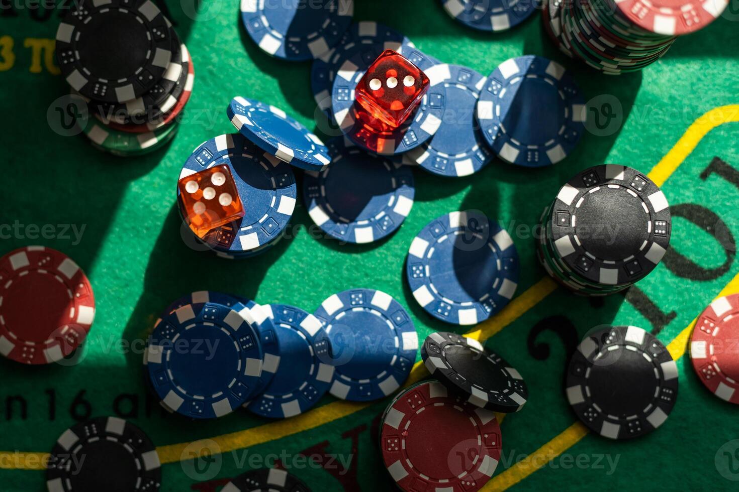 Gambling theme. Colorful playing chips in stacks on green table close up photo
