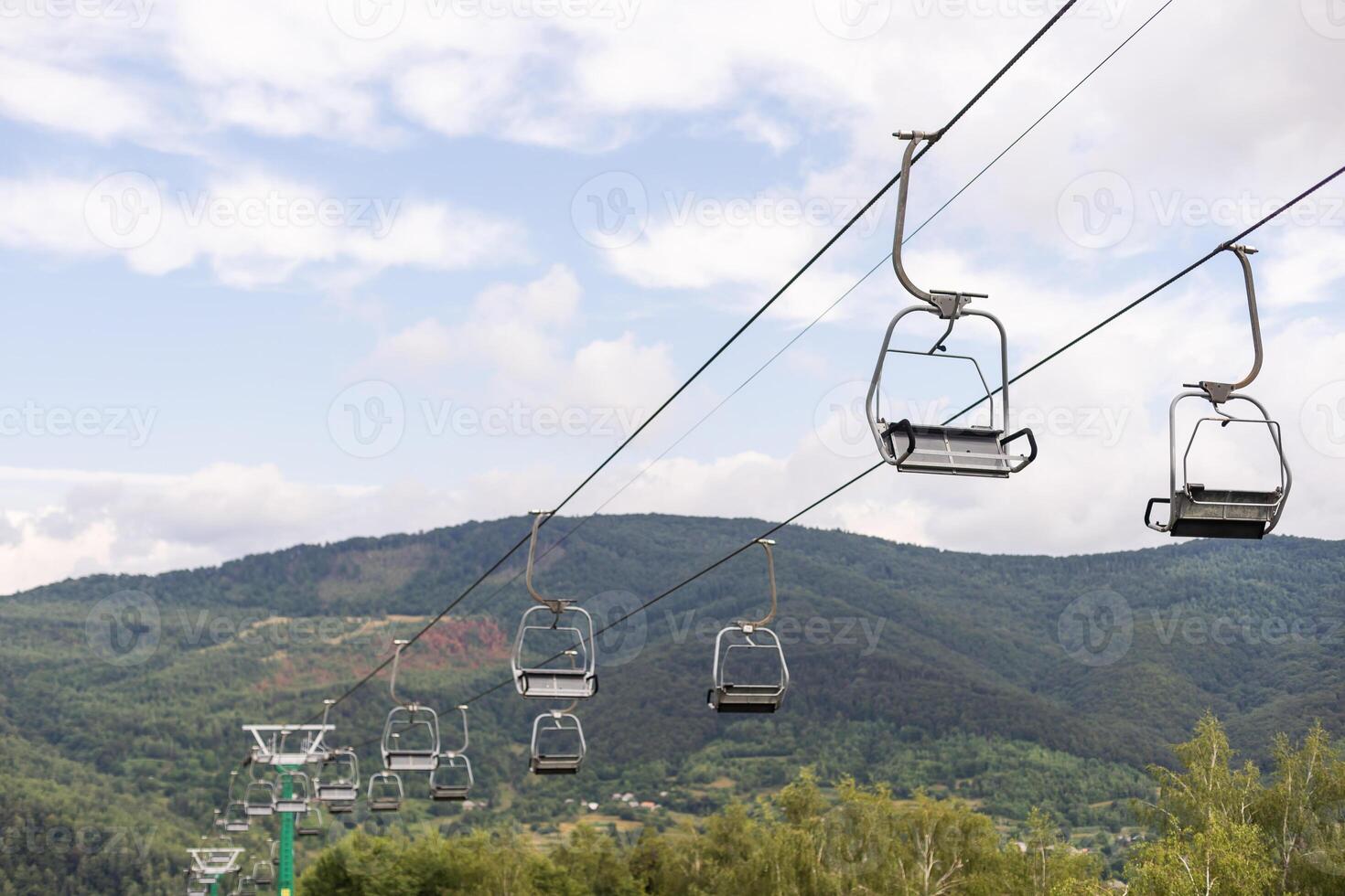 Mountain yellow lift on a summer day over the mountains. Old ski lift in the mountains in the sun. Carpathians, Ukraine. photo