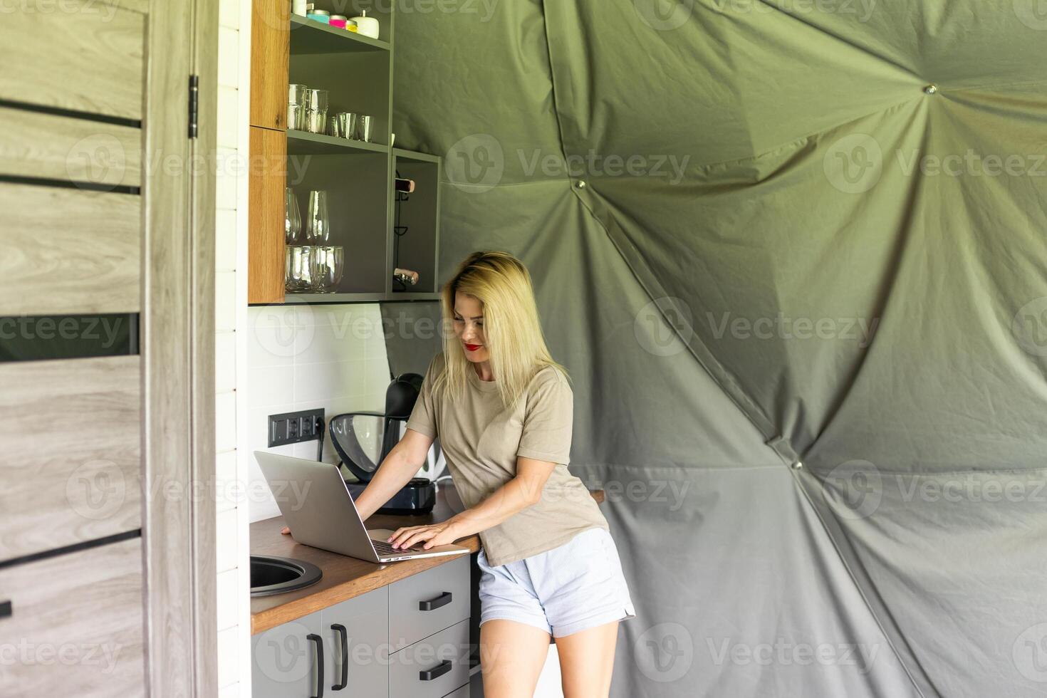 alegre rubia niña sonriente y hablando vía vídeo llamada en computadora portátil, hogar oficina, trabajando de forma remota, explicando un estrategia, persona de libre dedicación, que se discute un nuevo proyecto con equipo. foto