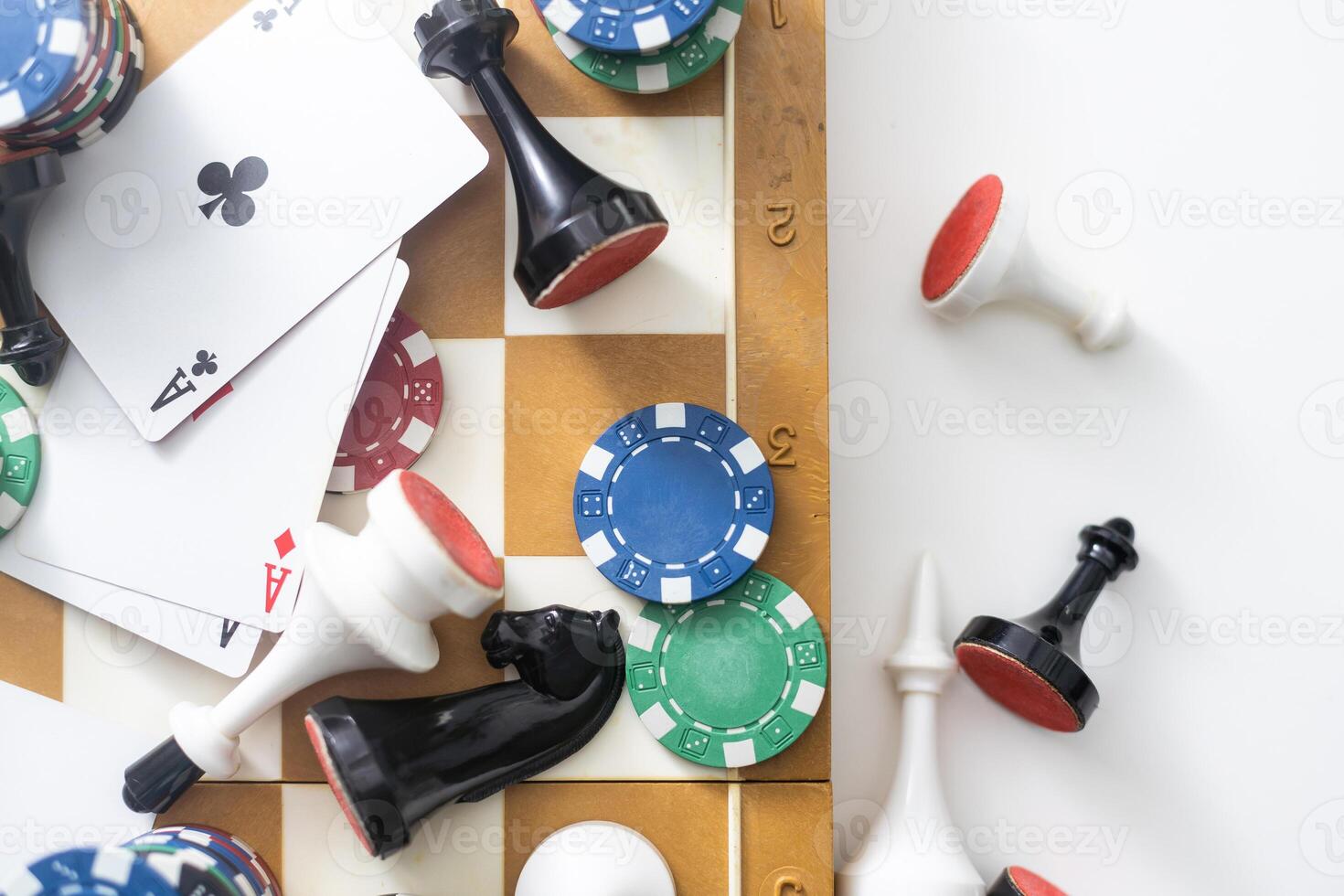 Wooden checkers, chess pieces, playing cards, board games on a light table close up. photo