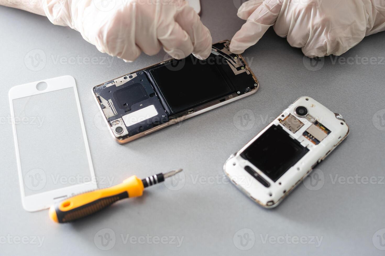 Technician repairing mobile phone at table, closeup photo