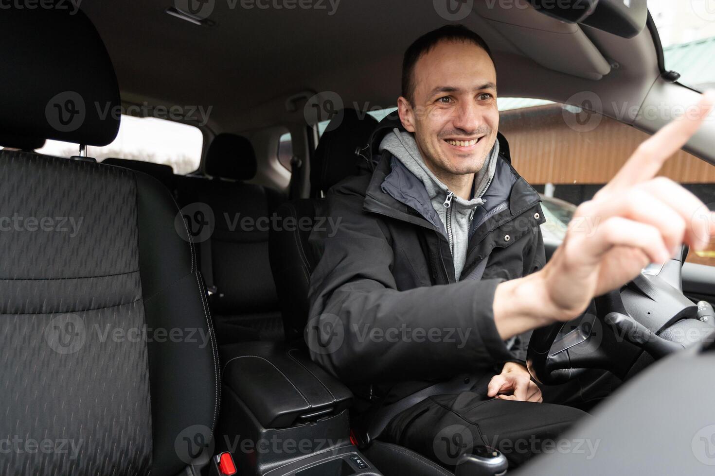 Handsome businessman driving car before buying photo