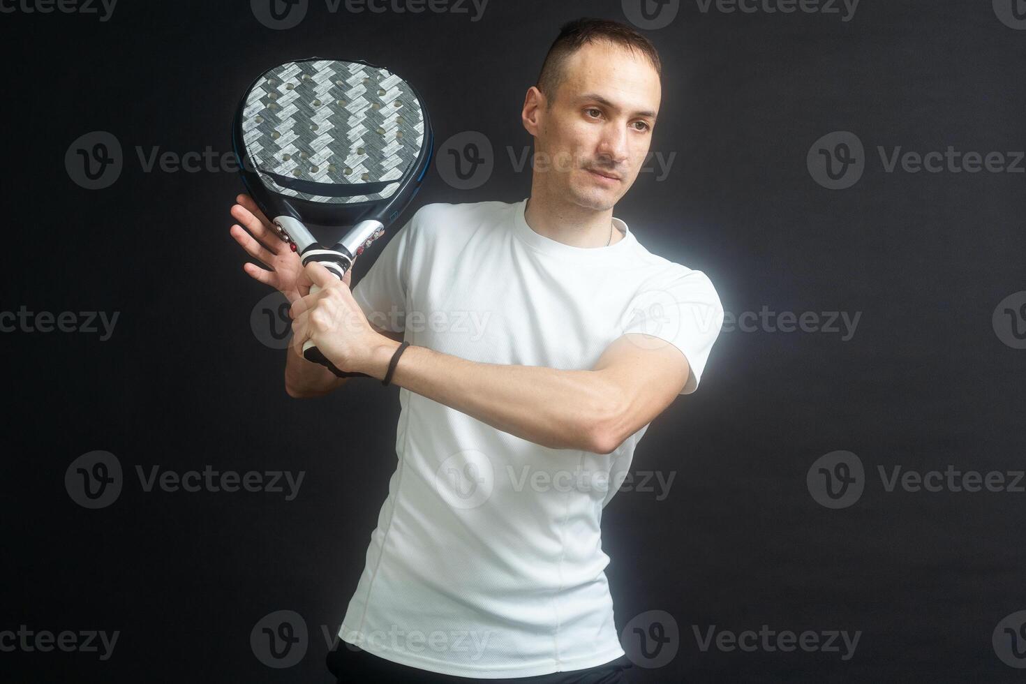 padel tenis jugador con raqueta en manos. paleta tenis, en un negro antecedentes. foto