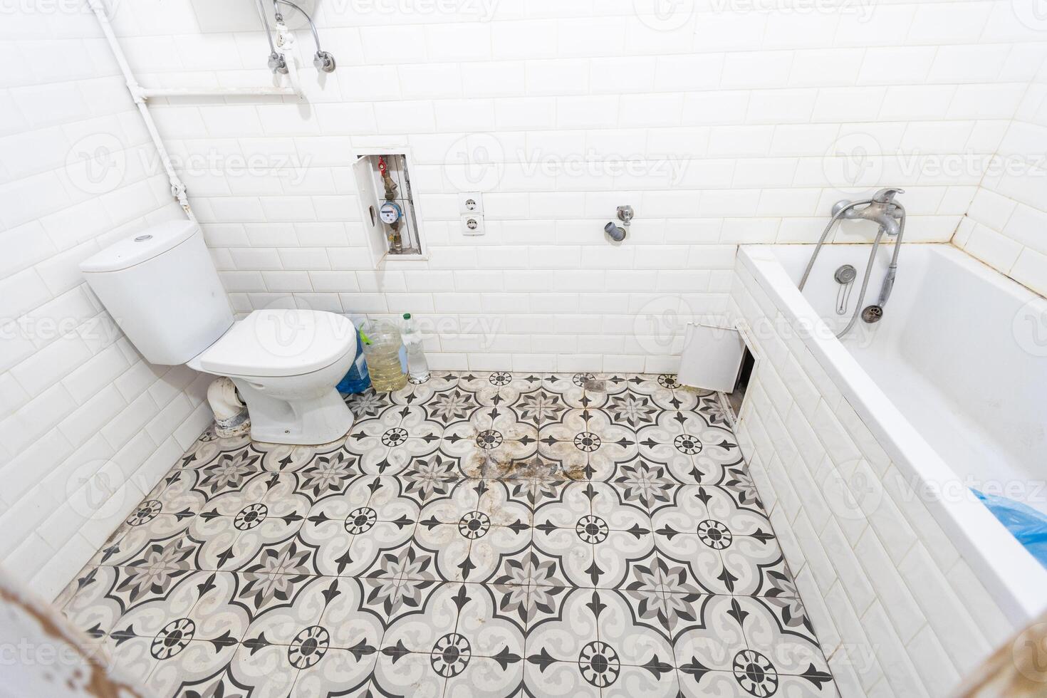 Interior of narrow restroom with wall hung toilet with white walls and checkered floor photo