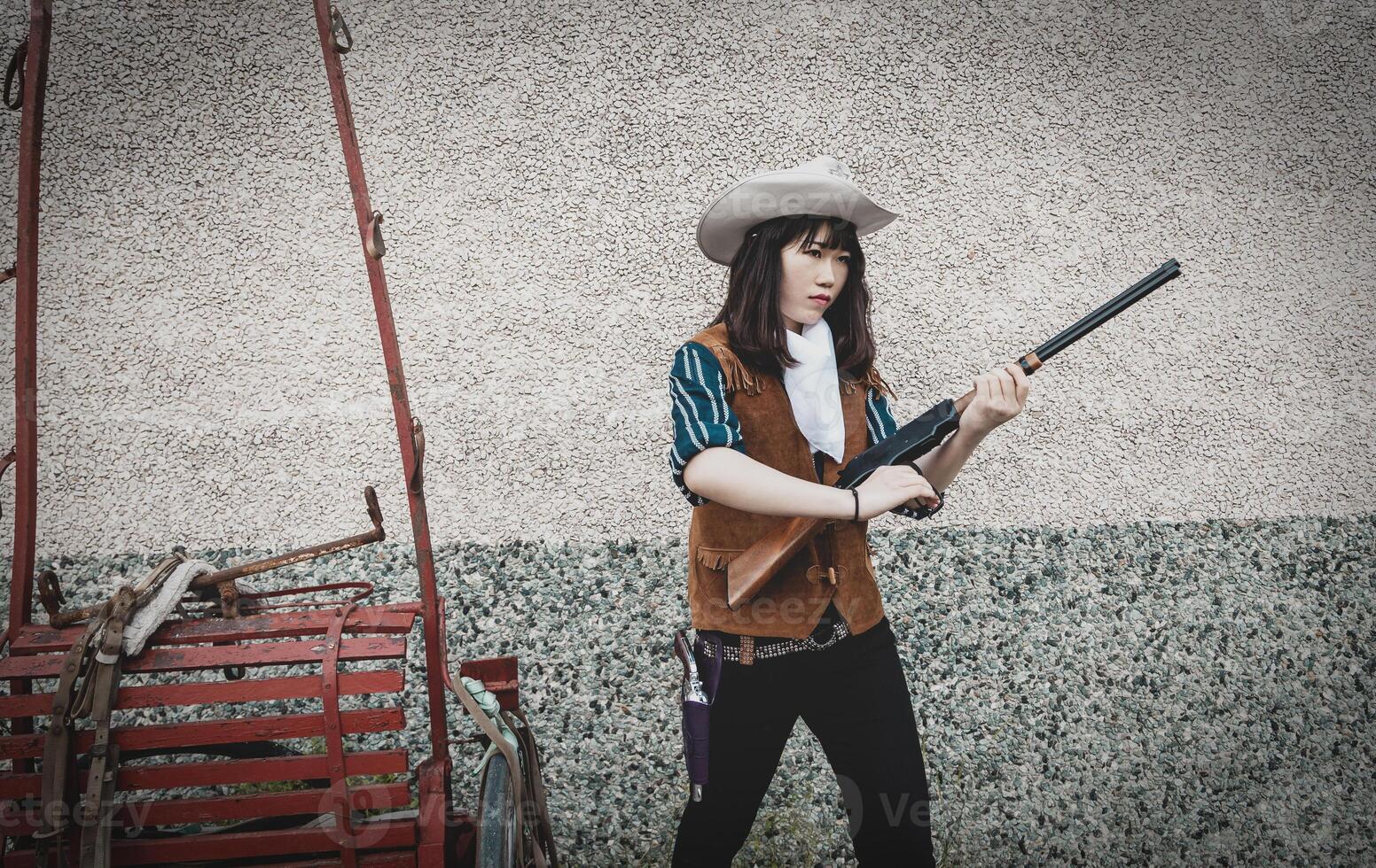 Portrait of a beautiful armed Chinese female cowgirl photo