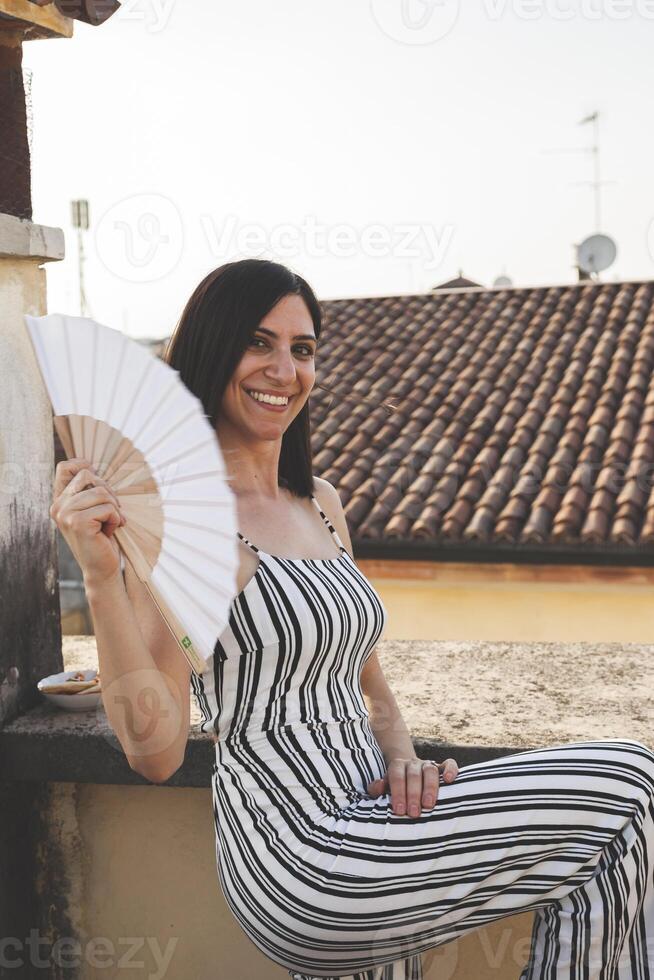 pretty woman having fun waving a folding fan photo