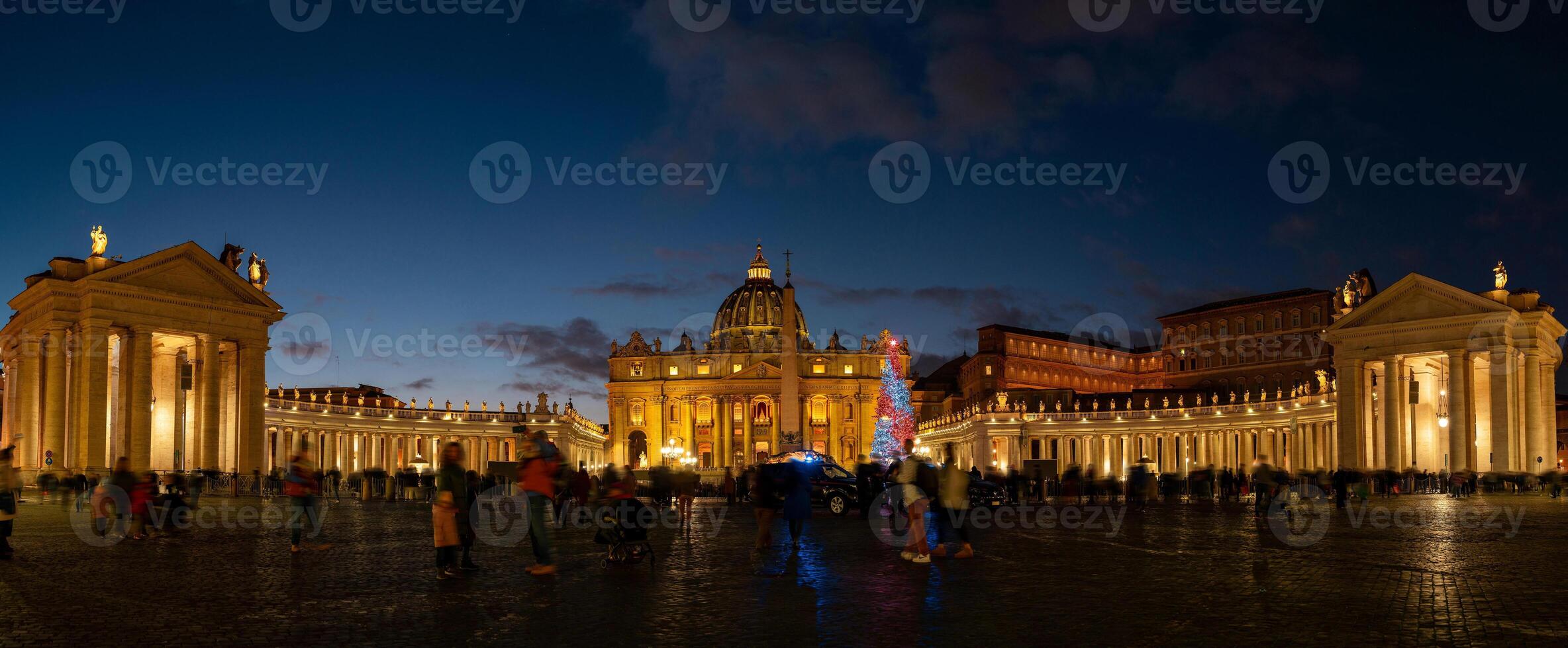 night view of St. Peter's Basilica illuminated and crowded with busy people photo