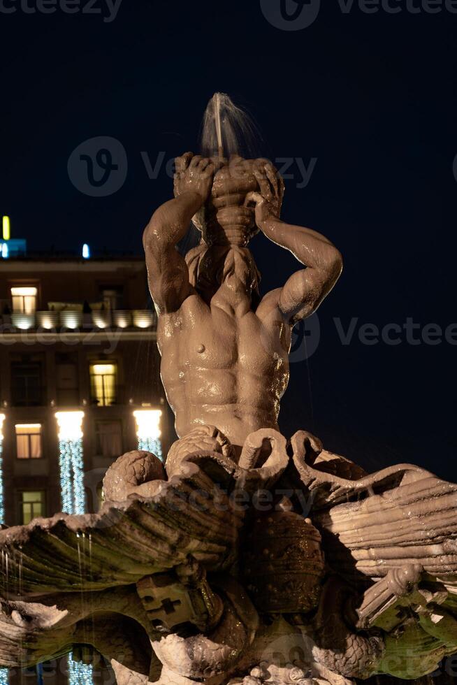 noche escena de tritón fuente en plaza barberini en Roma foto