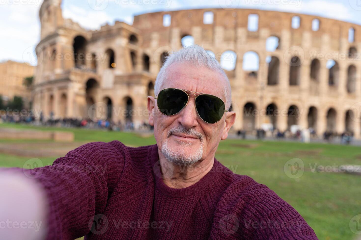 contento medio Envejecido hombre en vacaciones tomando un selfie en frente de Coliseo anfiteatro en Roma foto