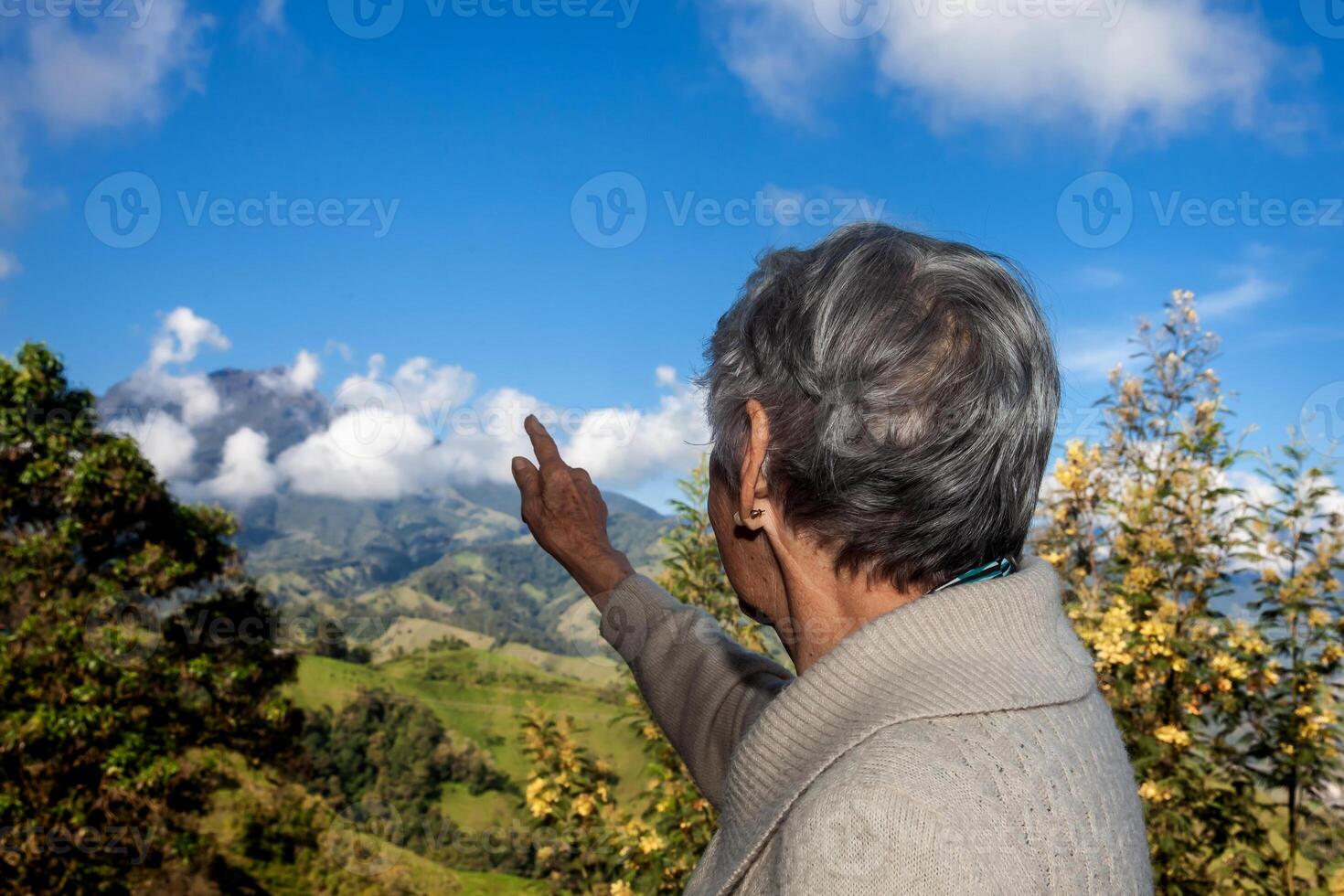 Senior woman tourist looking at the amazing landscapes of the Central Ranges on the ascent to the High of Letters between the cities of Fresno and Manizales in Colombia photo